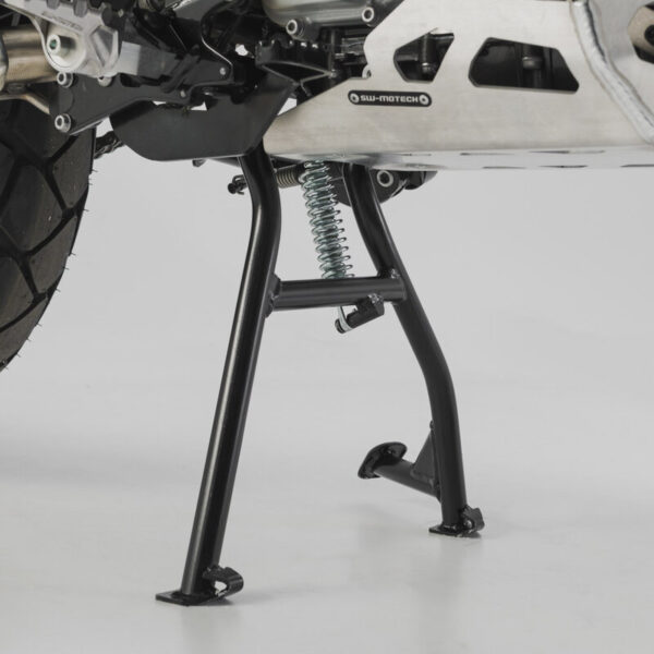 Κεντρικό σταντ SW-MOTECH σε μαύρο για BMW G 310 GS 2017–2020, τοποθετημένο σε μοτοσυκλέτα σε συνεργείο.